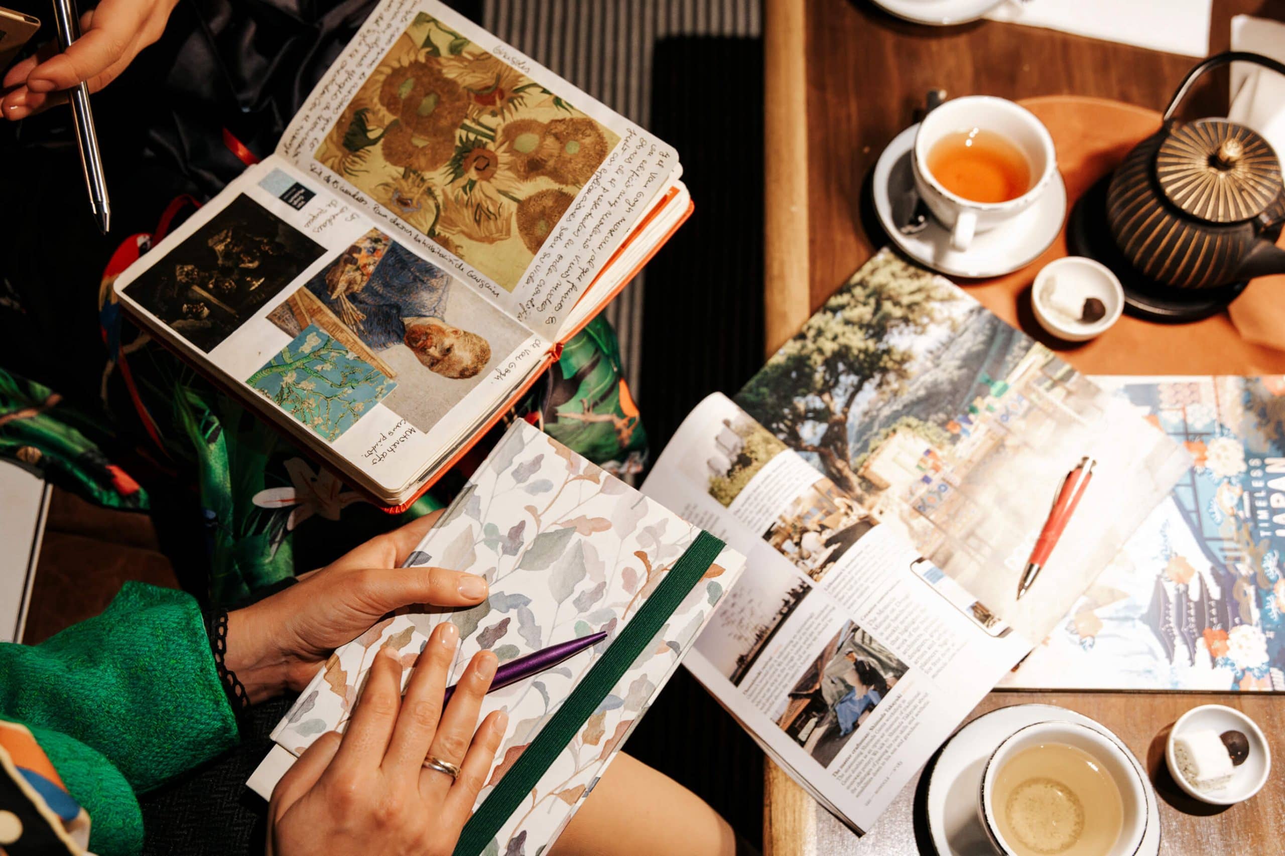 Proceso de diseño de viaje HeySole!: cuadernos de campo, libros de arte y notas de investigación sobre una mesa